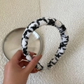 Dettaglio della trama intrecciata bianca e nera su un cerchietto per capelli chic - Sfondo Bianco Stile Stella Nera