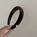 Detail of a brown velvet padded headband featuring a single white pearl and handmade label - Khaki