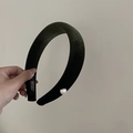 Dettaglio di un cerchietto in velluto verde con perla bianca ed etichetta a mano - verde scuro
