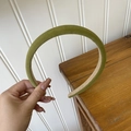 Dettaglio di un cerchietto in velluto verde con corona alta e struttura imbottita morbida - Verde