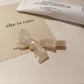 Elegante pinza francesa de acetato blanco perlado con lazo y acabado brillante de purpurina - Textura Blanco Plateado