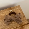 Close-up of brown knit bow hair tie with textured yarn and small gold metal ball charm - Coffee