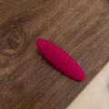 Nahaufnahme einer rosenroten Wollstoff-Entenschnabelklemme mit minimalistischer Webstruktur - Rosarot