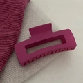 Elegante magenta matte haarklem voor dik haar gepresenteerd op een zachte stof - Rozerode Vierkante Haarklauw