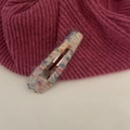 Gros plan détaillé d'une barrette BB en laine tricotée arc-en-ciel à texture douce - Blanc Cassé avec Points Colorés
