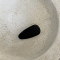 Detail of glossy black water drop hair clip on minimalist white ceramic tray - Black Triangle