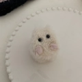 Primer plano de una linda pinza para el pelo de gato de peluche en un plato de cerámica - Pinza de Garra de Personaje de Dibujos Animados de Felpa Blanca