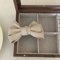 Elegant beige faux leather bow hair clip placed on a vintage wooden jewelry box - Bowknot Duckbill Clip / Off White