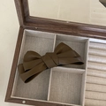 Close-up of a matte brown PU leather bow hair clip placed inside a wooden jewelry box - Bowknot Duckbill Clip / Dark Brown