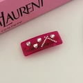 Détail de la barrette rectangulaire rose avec des strass en forme de cœur et finitions fines - Rouge