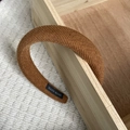 Donkerbruine geweven gevoerde haarband met handgemaakt label in een gezellige setting - Gembergeel Twill Textuur