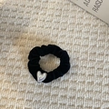 Macro shot of black velvet scrunchie with vertical texture and silver heart pendant detail - Heart Pearl Scrunchie