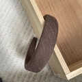 Detail van donkerbruine gewatteerde hoofdband in geribbelde gebreide stof op houten doos - Khaki Twill Textuur