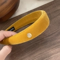 Detalle de diadema de terciopelo amarillo mostaza acolchada con etiqueta artesanal - Amarillo