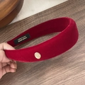 Primer plano de diadema de terciopelo rojo con etiqueta dorada hecha a mano clásica - Rojo