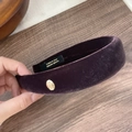 Primer plano de diadema de terciopelo vintage con logotipo dorado y etiqueta artesanal - Morado
