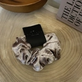 Close-up of champagne velvet scrunchie on wood background with branded packaging - Bright Champagne