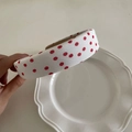 Detailed macro view of a padded white headband featuring classic red polka dots - White Red Polka Dot
