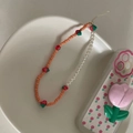 Détail de la dragonne de téléphone avec breloques fraises 3D et perles mates roses - Orange Fraise Perle