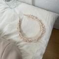 Detalle de una diadema de seda plisada color crema con textura suave de efecto nube - Blanco