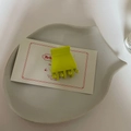 Gros plan d'une petite pince à cheveux vert mat sur un plateau décoratif en céramique blanche - Pince Carrée Vert Citron