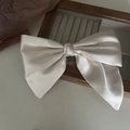 Elegant cream satin oversized bow hair clip with a silky glossy finish and vintage style - Off White