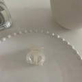 Mini pinza de pelo de acetato crema con elegante textura de nácar sobre plato porcelana - Estilo Textura Nácar / Plata