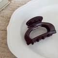 Dettaglio del fermaglio per capelli in acetato marrone con scritta dorata Handmade - Borgogna