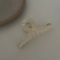 Détail de la pince à cheveux en acétate crème avec lettrage doré Barrette La France - Texture Blanc Argenté