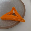 Dettaglio di un fermaglio a triangolo arancione brillante con finitura in acrilico - Triangolo Arancione