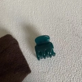 Dark green glossy acetate hair claw clip displayed on a minimalist white textured background - Blue