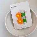 Close-up of two cute orange flower hair clips on a decorative handmade paper card - Orange Flower Green Base