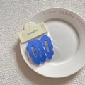 Detailed view of three blue wavy hair clips on a card inside a ceramic tray - 7# Dark Blue
