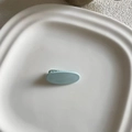 Vista detallada de una pinza para el cabello ovalada azul mate sobre bandeja de cerámica - Azul Cielo (2#)