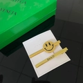 Detail view of yellow smiley face hair clip and Smile text clip on white card display - Gold Smiley Face Two-piece Set