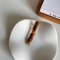 Dettaglio di un fermaglio per capelli a tartaruga con bordi ondulati su vassoio - Tartarugato Trasparente Ondulato