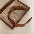 Morandi caramel brown pleated fabric headband displayed on a vintage wooden jewelry box - Caramel color