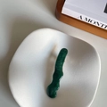 Vista dettagliata del fermaglio per capelli ondulato verde scuro marmorizzato su ceramica - Onda Verde