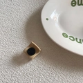 Dettaglio di un piccolo fermaglio per capelli beige opaco con stemma smiley nero - Base Tè al Latte (Faccina Nera)