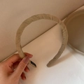 Detailed macro view of the cream handmade fabric headband with pleats and interior label - Coffee