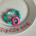 Tiffany blue scrunchie with large pink resin letter D charm on white ceramic plate - Green Scrunchie With Magenta Letter