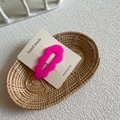 Cute wavy rose pink resin hair clip on a white card display in a woven basket - Fuchsia