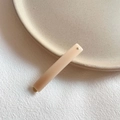 Elegant cream pink acrylic hair clip with silver dot detail on a ceramic plate - Off White