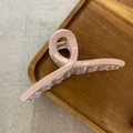 Dettaglio di una grande pinza per capelli rosa effetto ghiaccio su vassoio di legno - Rosa