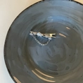 Elegante zilveren vlinder hart haarclip met zirkoon en ketting op een keramisch bord - Zilveren Strass Ketting Eendensnavel Clip