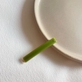 Detail shot of a minimalist grass green acrylic hair clip with small sparkling crystal studs - Green