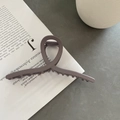 Detailopname van grote mat grijs-paarse haarklem met elegant kruisontwerp op een boek - Grote Kruisstijl / Khaki