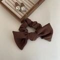 Dettaglio scrunchie a fiocco marrone scuro in tessuto waffle e orecchini gemma - Cachi