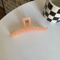 Close-up of translucent peach jelly acrylic hair claw clip with visible metal spring - Orange Long Bar