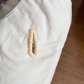 Detailaufnahme der cremefarbenen Zopfmuster-Stoffhülle eines Tropfenform-Haarclips - Off-White